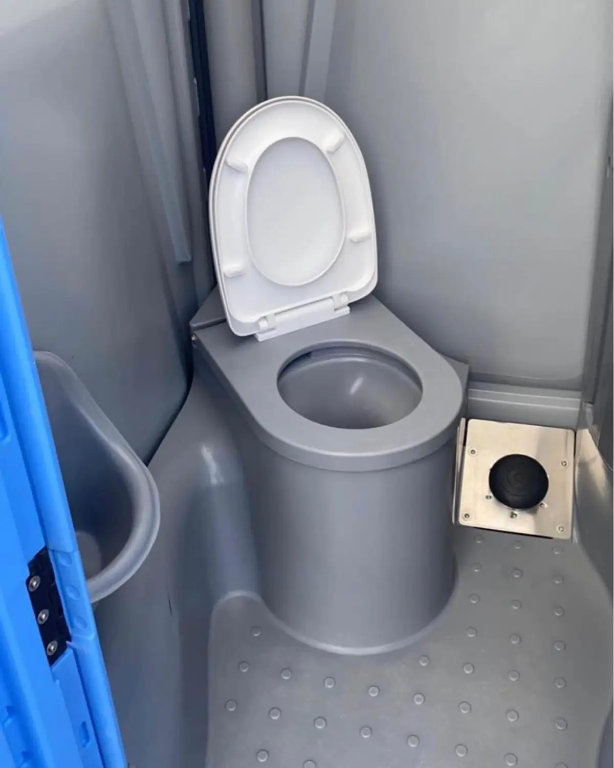 White toilet seat inside a gray deluxe flushing porta potty