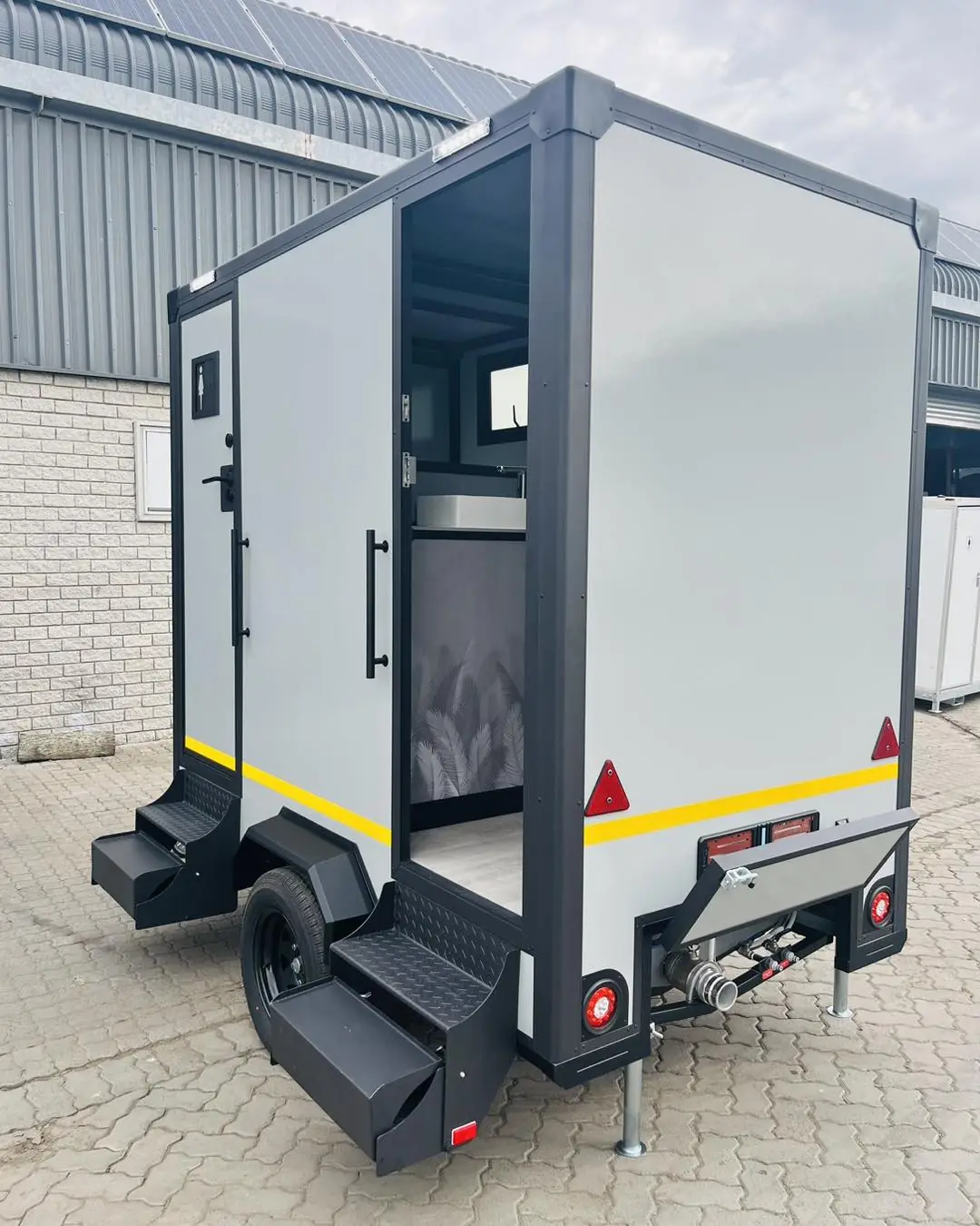 Restroom trailer with fold-down rear steps
