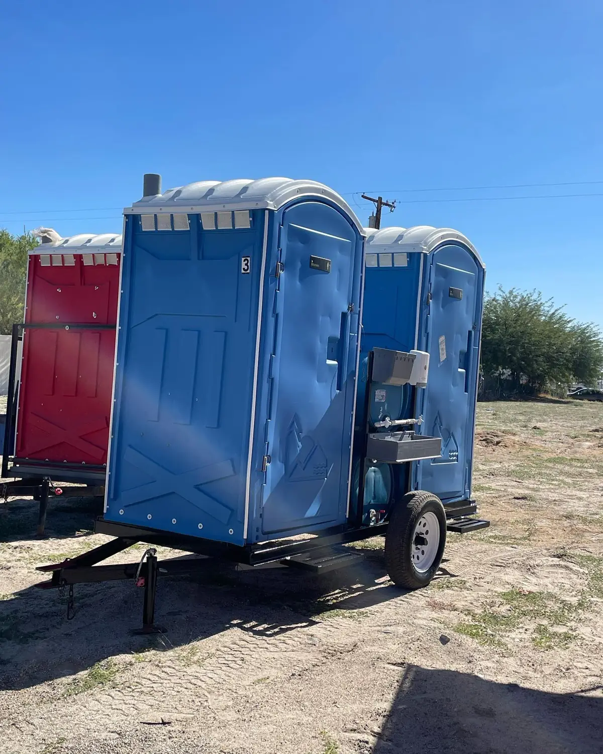 Porta potties on a trailer in a farm field
